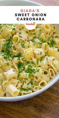 a white bowl filled with macaroni and cheese on top of a wooden table