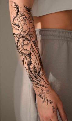 a woman's arm with flowers and leaves on it