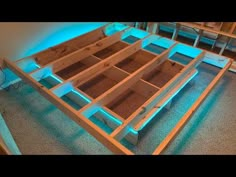 an unfinished bed frame is lit up with blue light from the bottom and side lights