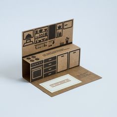 an open cardboard box with a cutout of a kitchen on the front and inside