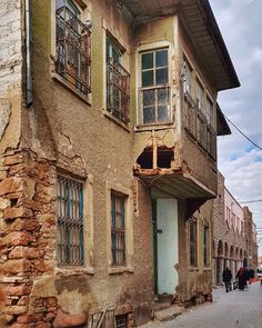 an old building with people walking down the street