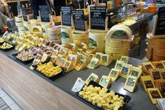 many different types of cheese on display at a market