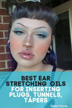 a woman with blue hair and piercings on her nose is looking at the camera