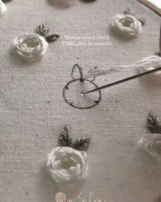 a close up of a piece of cloth with flowers on it and some thread in the middle