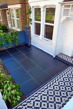 a black and white tiled patio with potted plants