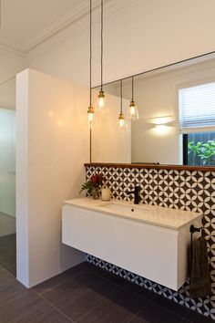 a white sink sitting under a bathroom mirror next to a wall mounted faucet