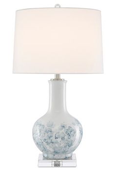 a white lamp with blue flowers on it