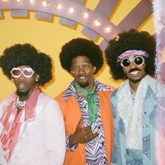 three men with afro hair and sunglasses posing for a photo