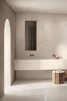 a bathroom with a sink, mirror and two baskets on the floor