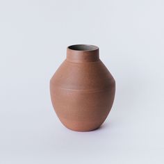 a brown vase sitting on top of a white table