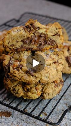 cookies stacked on top of each other on a cooling rack with chocolate chips in the middle