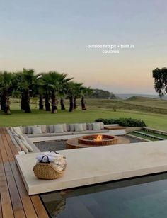 an outdoor fire pit in the middle of a wooden deck next to a large pool