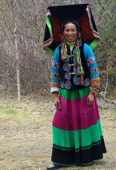 a woman in a colorful dress holding an umbrella over her head