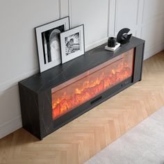 a modern fireplace in the middle of a room with two pictures on top of it