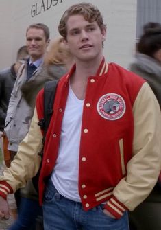 a man wearing a red and yellow varsity jacket