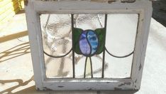 a stained glass window sitting on top of a cement ground