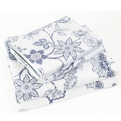 two sheets with blue and white flowers on them, one is folded to the side