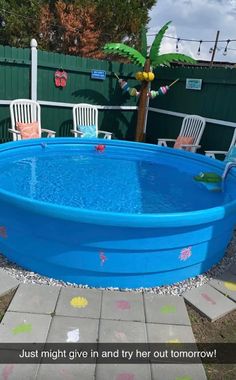 an above ground pool with chairs around it and a palm tree in the back yard