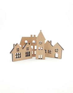 three wooden houses are shown on a white background, one is cut out and the other is made from wood