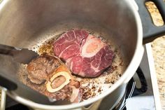 some meat is cooking in a pot on the stove