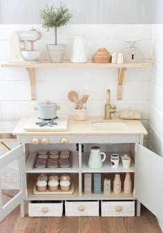 a kitchen with wooden floors and white walls