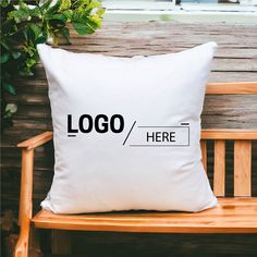 a white pillow sitting on top of a wooden bench next to a potted plant