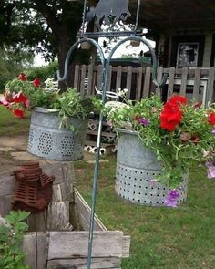 two metal buckets with flowers hanging from them