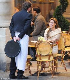 a man and woman sitting at an outdoor table