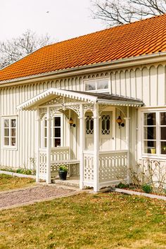 a small white house with an orange roof