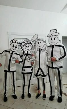 five people in costumes standing next to each other with paper cutouts on their faces