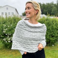 a woman wearing a gray knitted shawl