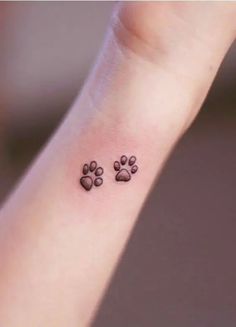 a small paw print tattoo on the wrist