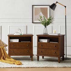 two nightstands side by side with books and magazines on them in a living room