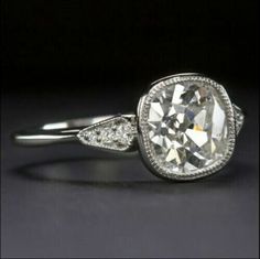 a white gold ring with an oval cut diamond and pave set diamonds on the sides