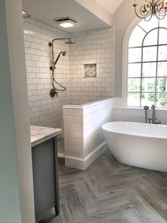 a large white bath tub sitting next to a window