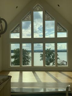 an empty room with large windows overlooking the water