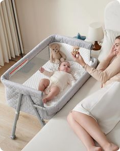 a woman laying in bed next to a baby