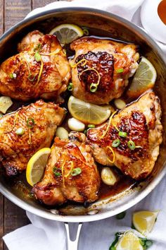 honey lemon garlic chicken in a skillet with lemon slices and garnishes