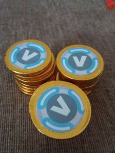 three stacks of gold coins sitting on top of each other with the letters v in blue