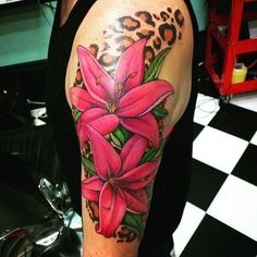 a woman's arm with pink flowers and leopard print on the back of it