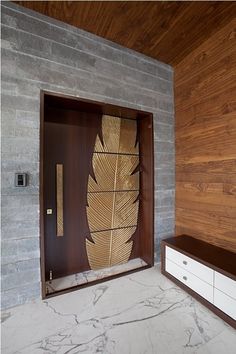 a room with a large wooden door and white drawers