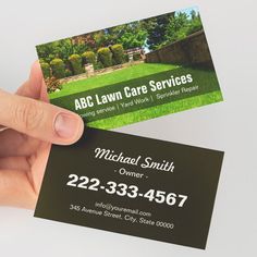 a person holding up a business card for lawn care services