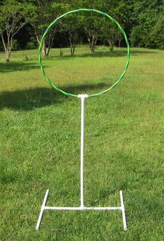 a white pole with a green ring on it in the grass