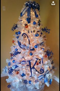 a white christmas tree decorated with blue and silver ornaments