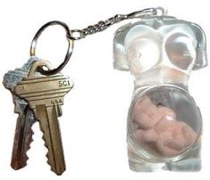 a keychain with a small teddy bear inside of it and a glass bottle filled with keys