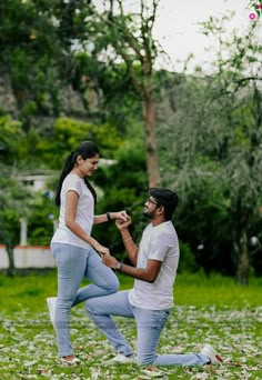 a man kneeling down next to a woman who is touching her finger with the other hand