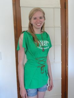 a young woman is standing in front of a door wearing shorts and a green shirt