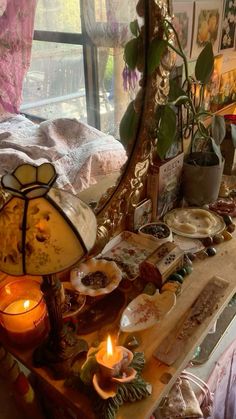 a table topped with plates and candles next to a mirror