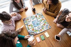 a group of people sitting around a table playing a game