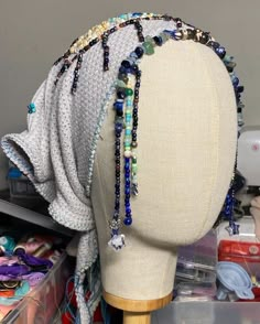 a mannequin with many beads on it's head and some other items in the background